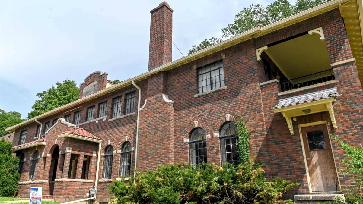 A grand 1929 brick historic building, Sienna, perched on North Court Street hill in Ottumwa, Iowa, featuring a new historically appropriate roof and views overlooking the local library and park.