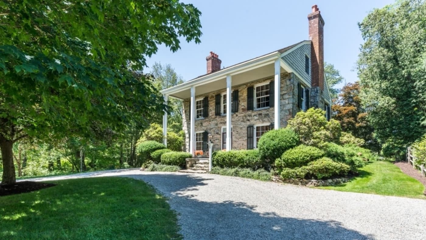 The historic first home built in the Smoke Rise community of Kinnelon, NJ, for sale on PreservationDirectory.com. This landmark residence features classic stone masonry, rustic timber accents, and mid-century architectural charm in a wooded setting.