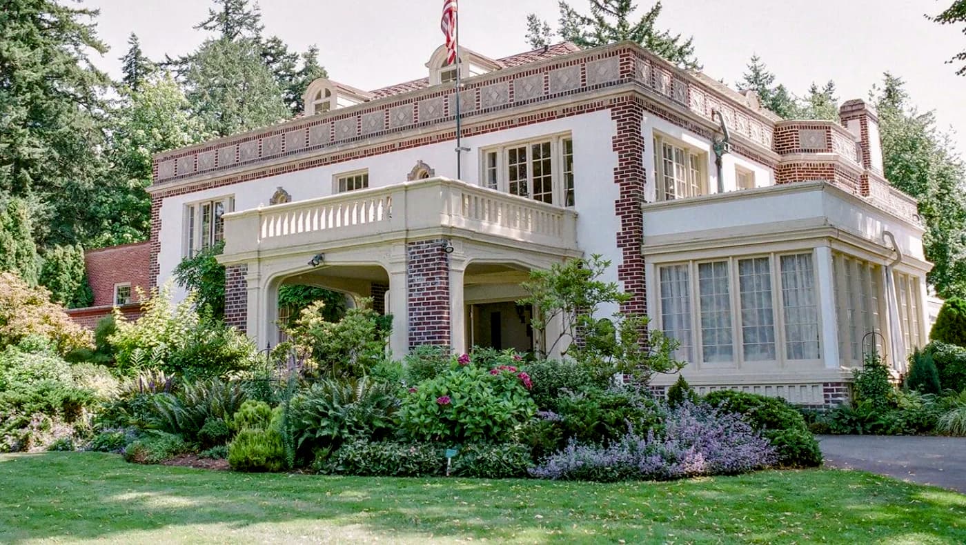 Front exterior of Lairmont Manor, a historic Italian Renaissance Revival estate in Bellingham, WA, featuring ornate limestone detailing, arched windows, and a grand circular driveway.