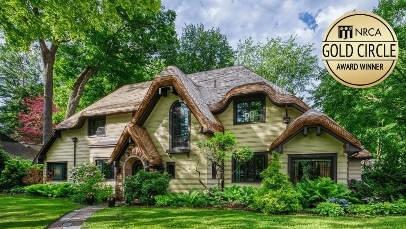Alt text for photo of an English cottage with a false thatched roof that won an NRCA Gold Circle award for Huber & Associates.
