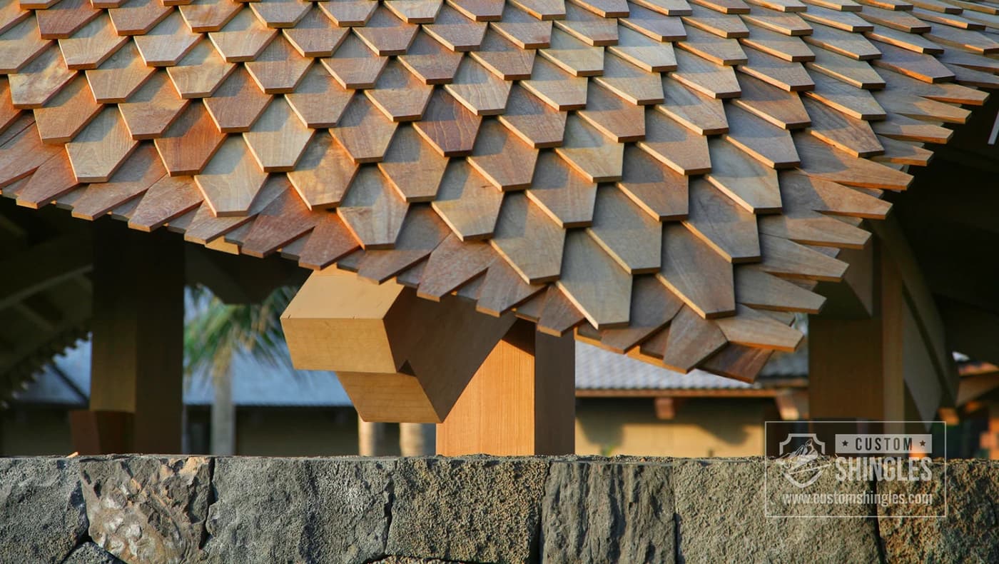 Close-up of exotic teak wood roofing shingles from Custom Shingles in Lake City, FL. The shingles are precision-cut in a pointed "Dragon’s Tooth" profile, showcasing the tight wood grain and rich, natural oils of the gold-standard teak material.