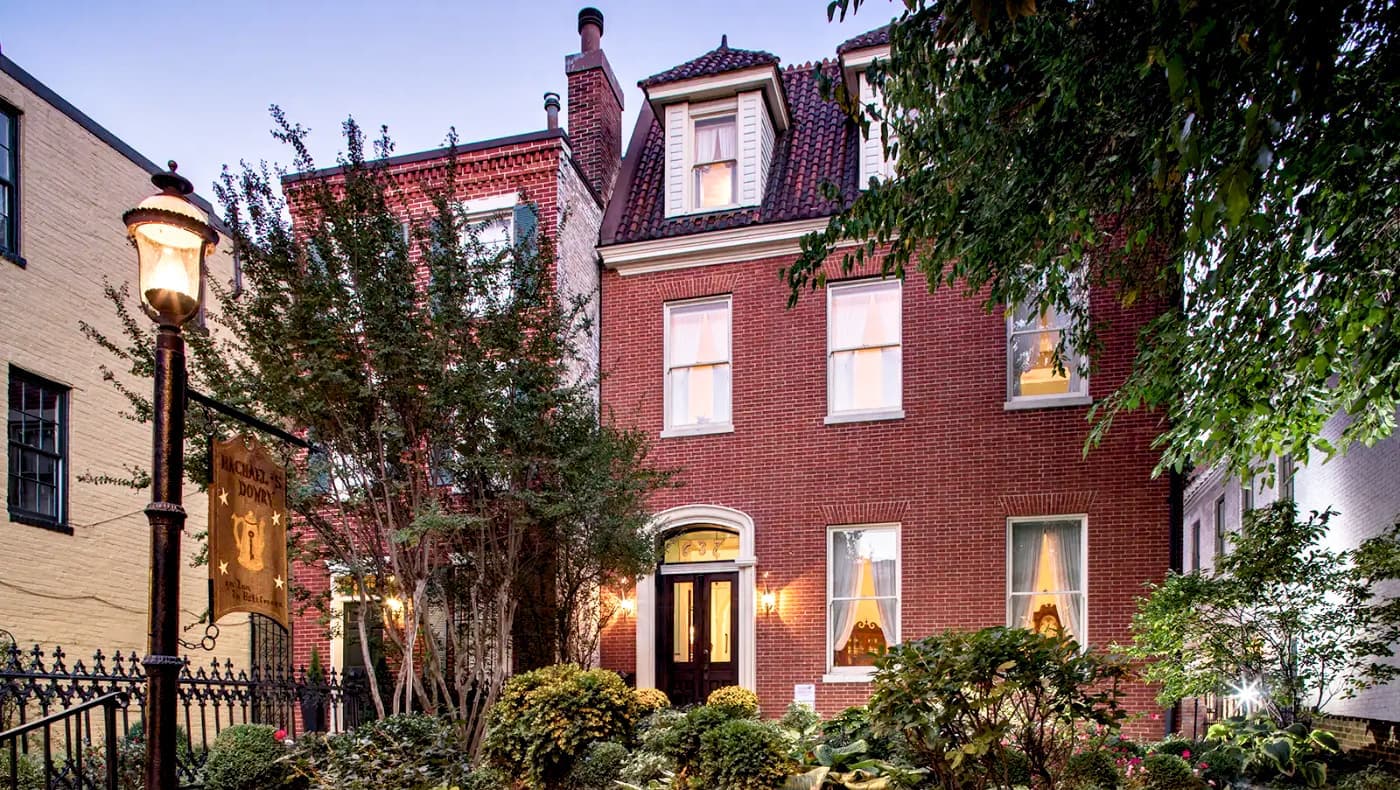 Front exterior of Rachel’s Dowry Bed and Breakfast in Baltimore, Maryland, a historic 1790s red-brick federalist townhouse with white trim and a welcoming front entrance.