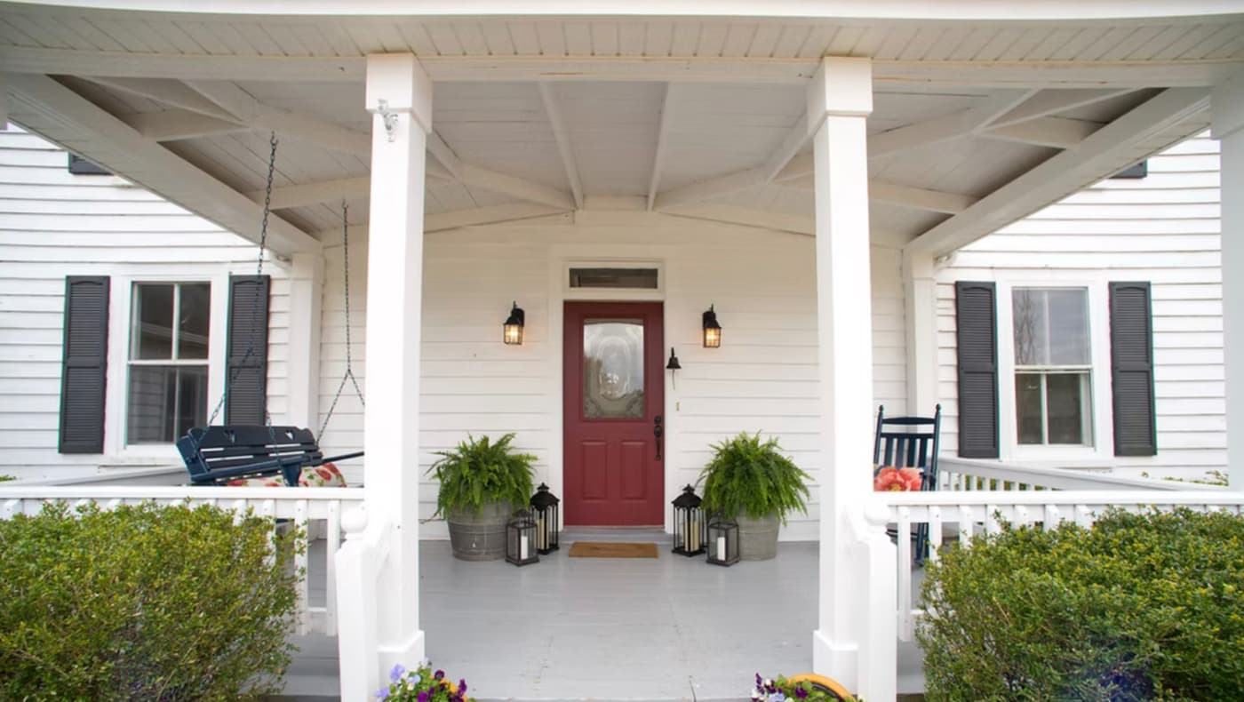 Front exterior view of The Bed and Breakfast at Peace Hill, a historic farmhouse featuring a wide, welcoming covered porch with classic white columns.