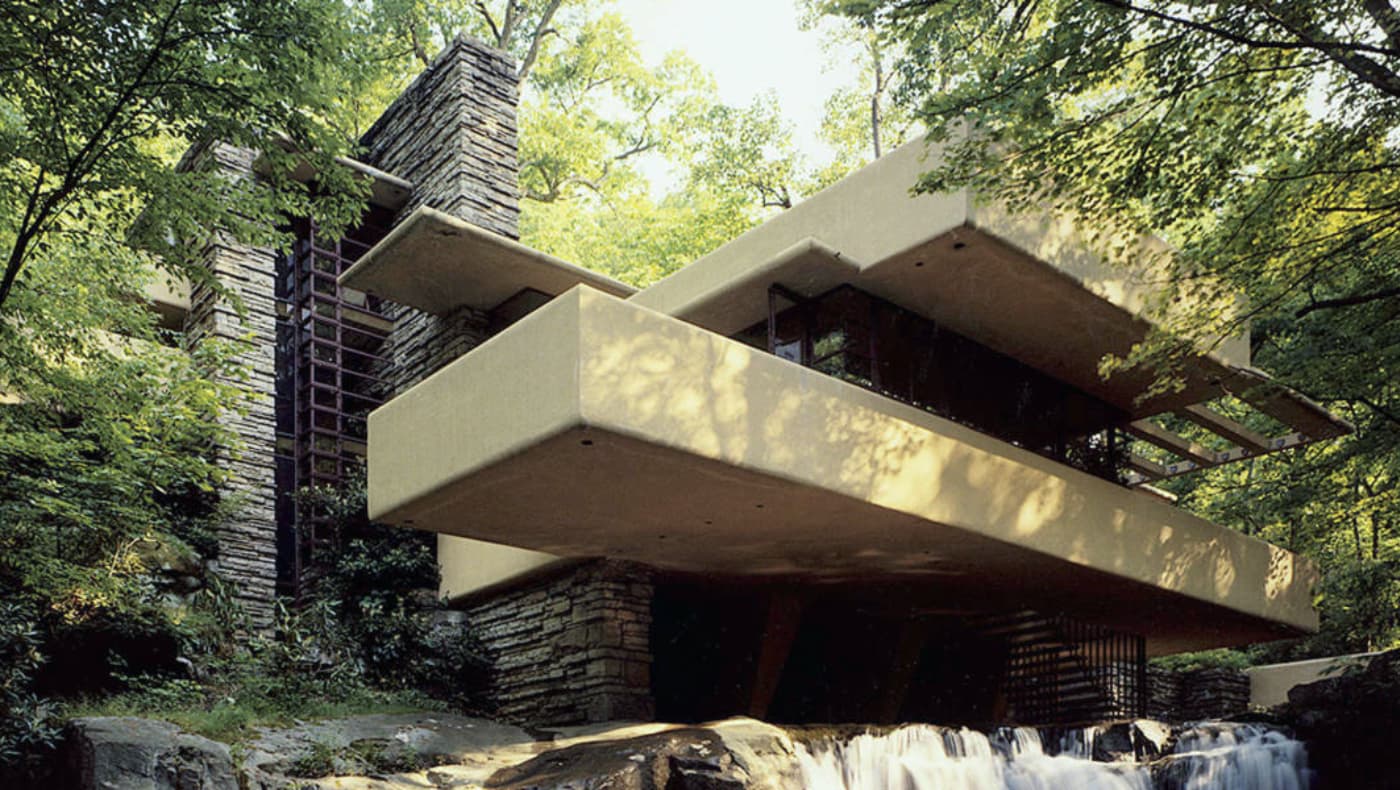Exterior view of Fallingwater, the iconic Frank Lloyd Wright-designed residence in Mill Run, PA. The house features dramatic reinforced-concrete cantilevered terraces that extend directly over a rushing waterfall on Bear Run.