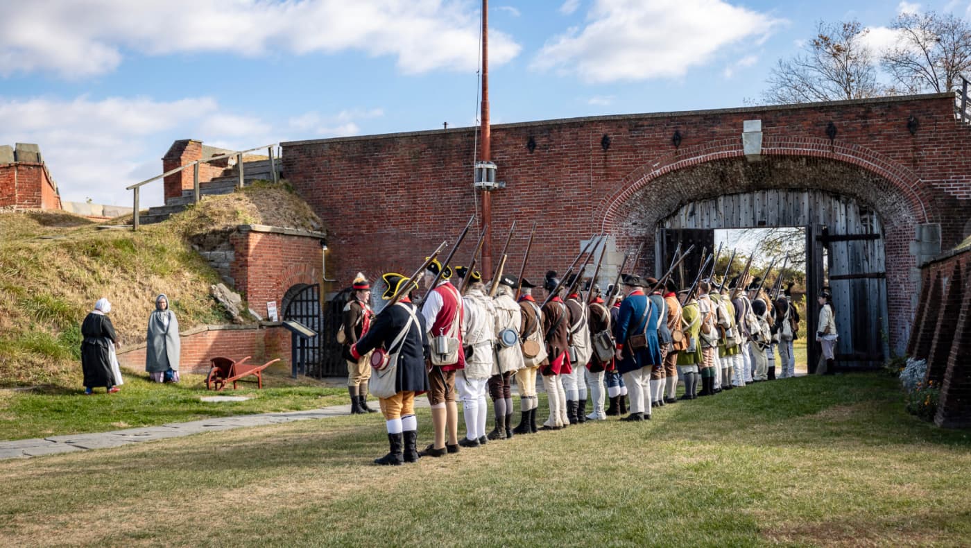 Historic reenactors dressed as Revolutionary War soldiers perform a military drill at Fort Mifflin in Philadelphia.