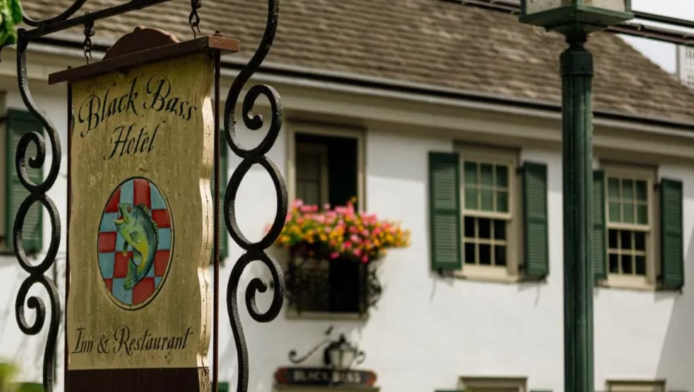 The historic fieldstone exterior and front sign of the Black Bass Hotel and Restaurant in Bucks County, Pennsylvania.