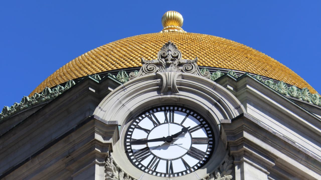 The exterior of the Buffalo Savings Bank building in Buffalo, NY, featuring its iconic large gold-leafed dome and Beaux-Arts architectural details.