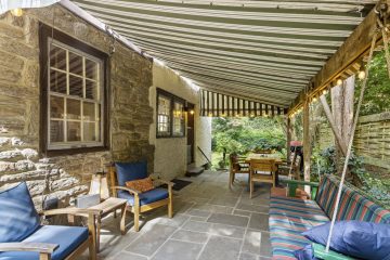 1938 Tudor Revival at 419 Lodges Lane, Elkins Park, Pennsylvania: covered side patio with canvas awning and porch swing
