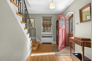1938 Tudor Revival at 419 Lodges Lane, Elkins Park, Pennsylvania: entry foyer with Gothic arched front door and iron stair railing