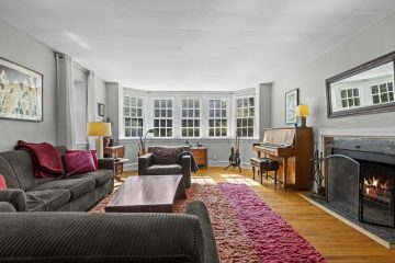 1938 Tudor Revival at 419 Lodges Lane, Elkins Park, Pennsylvania: living room with bay window and wood-burning fireplace