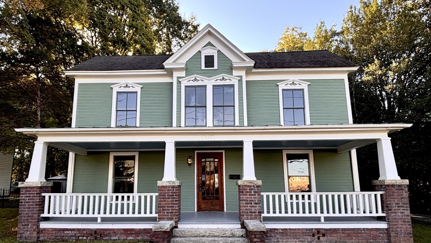 Lentz House in Salisbury, North Carolina: two-story house with green double-Dutch siding, a center gable and a full-width front porch on brick piers
